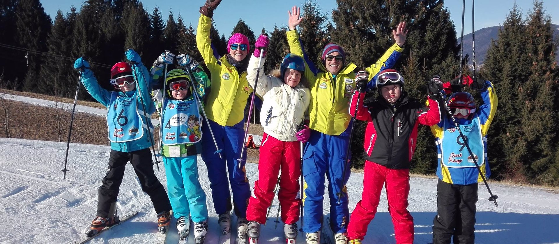 maestre di sci con bambini sulla neve